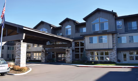 Exterior view of Bonaventure of Tigard senior living facility with covered entrance and parking.