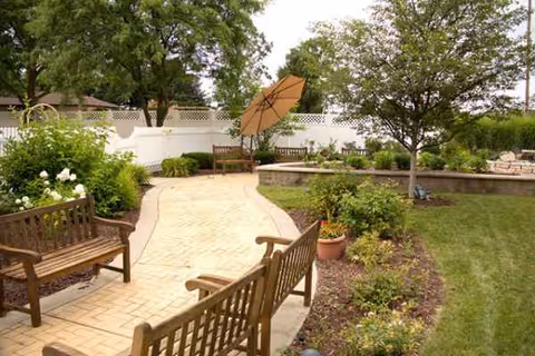 Outdoor courtyard at Isabella Co Medical Care Facil with benches, path and umbrella.