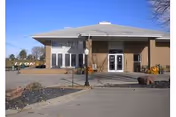 Front view of a brick Terrace Park Assisted Living building with glass doors and parking.