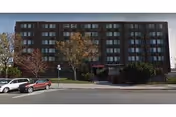 Grand Manor Nursing & Rehabilitation Center exterior: multi-story brick building with cars parked in front.