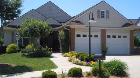 Front view of Twin Lakes Community Memory Care facility with manicured lawn and a two-car garage.
