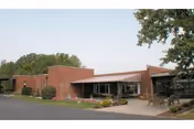 Exterior of Miller's Merry Manor brick facility with glass entry and landscaped front entrance.
