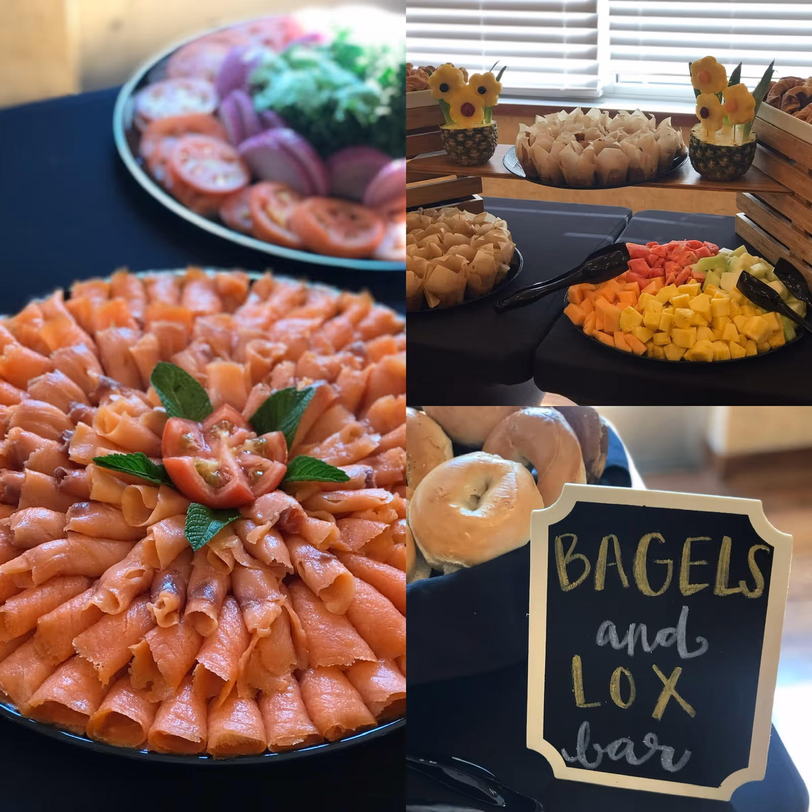 Buffet table featuring a large platter of rolled lox, bagels with a chalkboard sign reading 'Bagels and Lox bar', and assorted fruit and muffins.