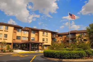 Front entrance of the AVIVA Baldwin Park building with an American flag and circular driveway.
