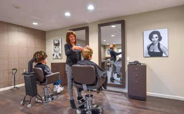 Hair salon inside Summit Senior Living Halfmoon with a stylist cutting a resident's hair.