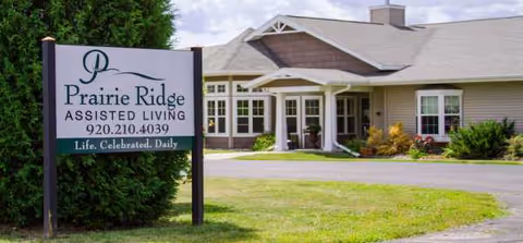 Prairie Ridge Assisted Living building entrance with a front sign and landscaping.
