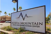 Outdoor sign for North Mountain Medical and Rehabilitation Center with palm trees in the background.