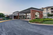 Exterior view of EverTrue Concordia Village entrance with brick arches and covered driveway.