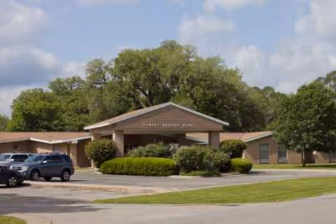 Front view of Towers Nursing Home entrance with a canopy and a parking lot.