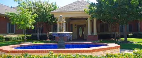 Front entrance of Grand Brook Memory Care of Grapevine with a circular brick fountain.