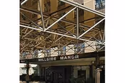 Exterior view of Hillside Manor Rehabilitation entrance with scaffolding overhead and sign.