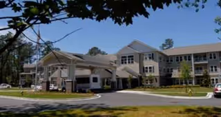 Exterior view of a multi-story senior living facility with a covered entrance and driveway.