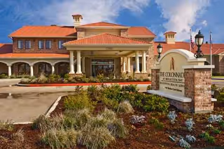 The Colonnades at Reflection Bay exterior entrance with landscaped front yard and sign