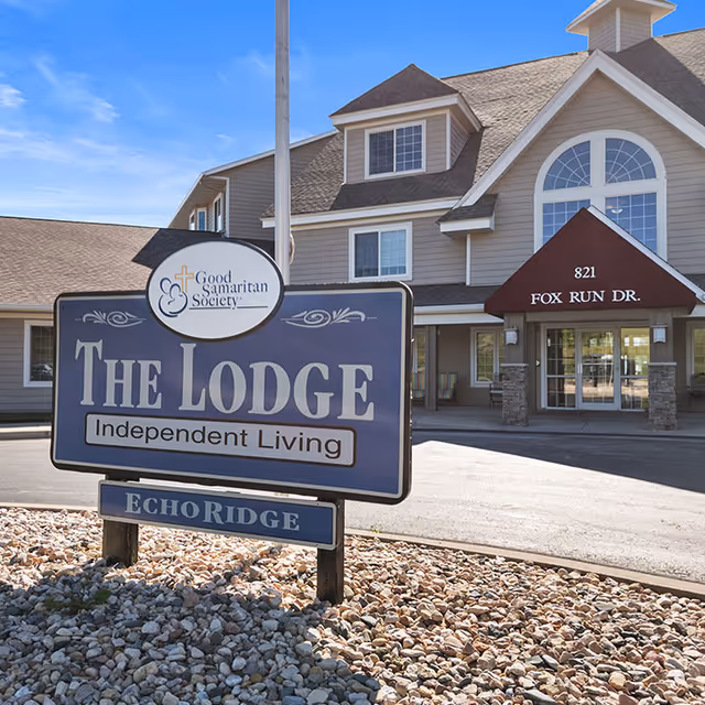 Front entrance of The Lodge at Echo Ridge independent living facility with a large outdoor sign and the building's entry canopy reading '821 Fox Run Dr.'