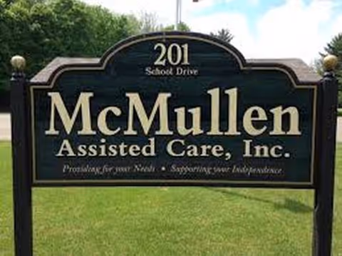 A large McMullen Assisted Care sign on a grassy lawn.