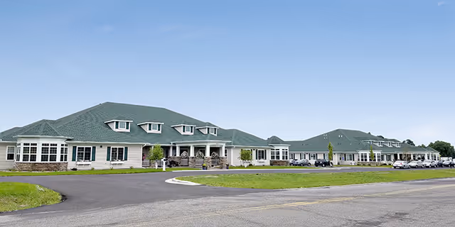 Front exterior view of Birchwood Cottage II senior living facility with green roof and parking lot