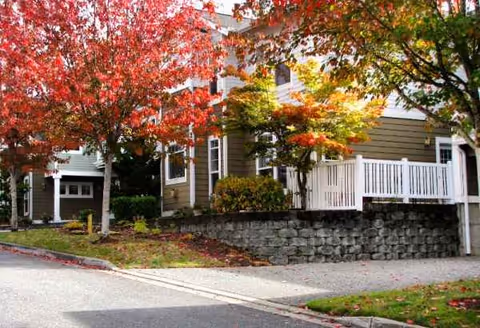 Exterior view of Providence Point building with stone wall, steps, and colorful autumn trees.