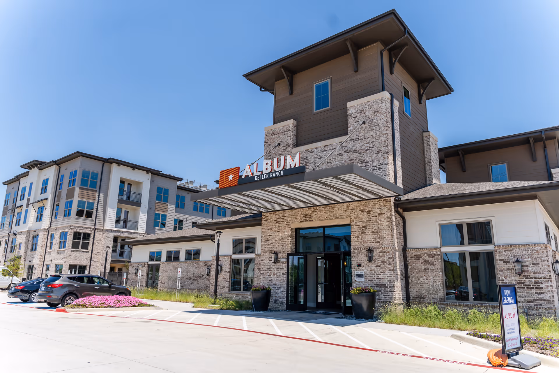 Exterior view of Album Keller Ranch senior living campus with brick facade and entry.
