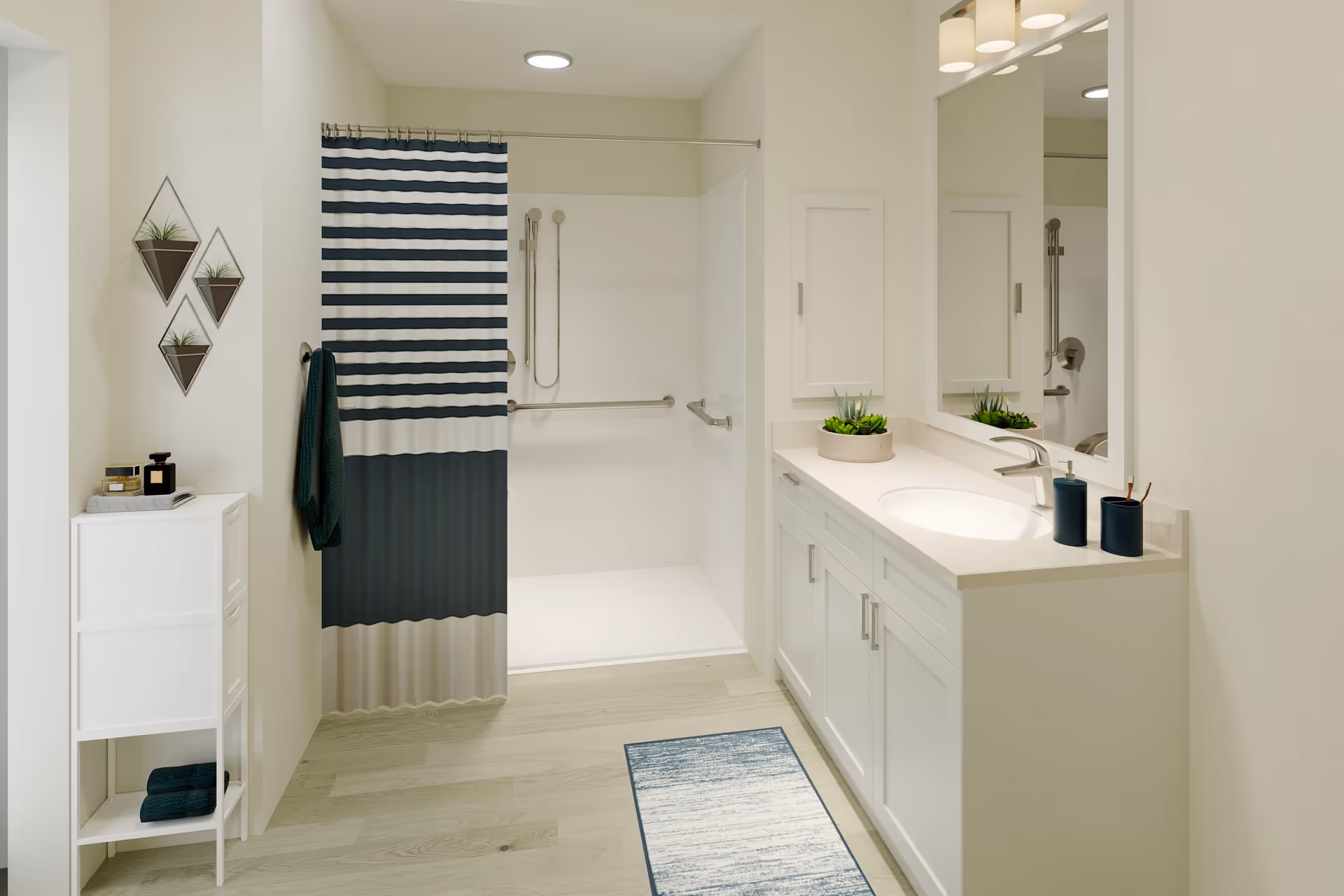 A clean, modern bathroom featuring a walk-in shower with a striped shower curtain in navy blue, white, and beige. The bathroom has light-colored walls and flooring, a white vanity with a sink, a large mirror, and small decorative plants. There is a towel hanging on the wall and a small white storage cabinet with toiletries and towels.