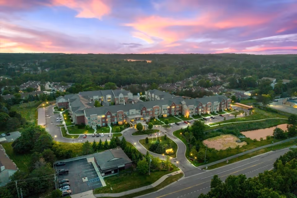 Aerial view of All Seasons West Bloomfield senior living campus at sunset.