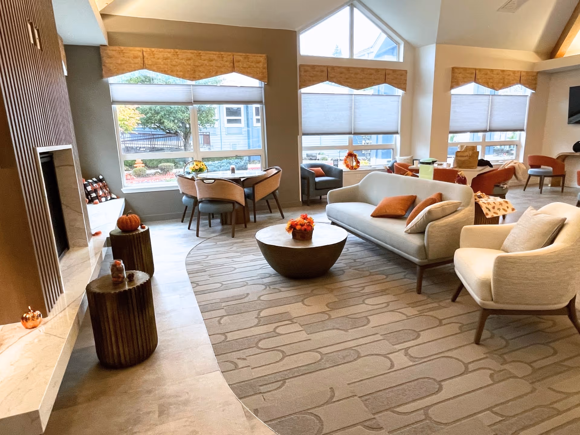 Bright senior living lounge with modern furniture, cozy seating, and large windows.
