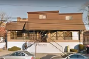 Two-story Wavecrest HFA senior living facility exterior with stairs and parked cars