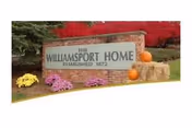 Front sign of Williamsport Home with pumpkins and autumn flowers.