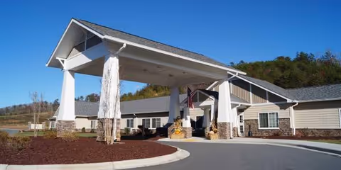 Front view of Franklin House senior living facility with a covered entrance and flag.