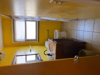 Small bathroom with yellow walls, a toilet, a sink vanity with mirror, and a window.