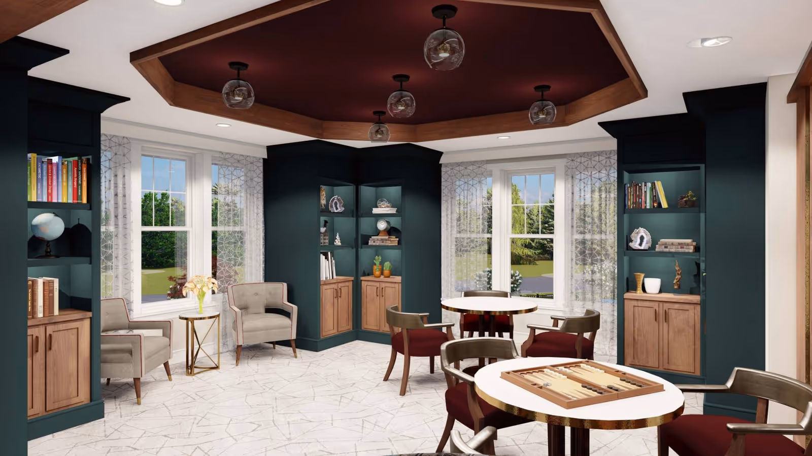 Bright communal lounge with round game tables, upholstered chairs, built-in shelving and large windows overlooking greenery.