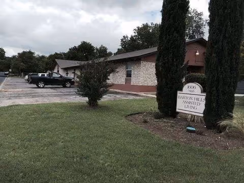 Front view of Barton Hills Assisted Living building with sign and parking lot.