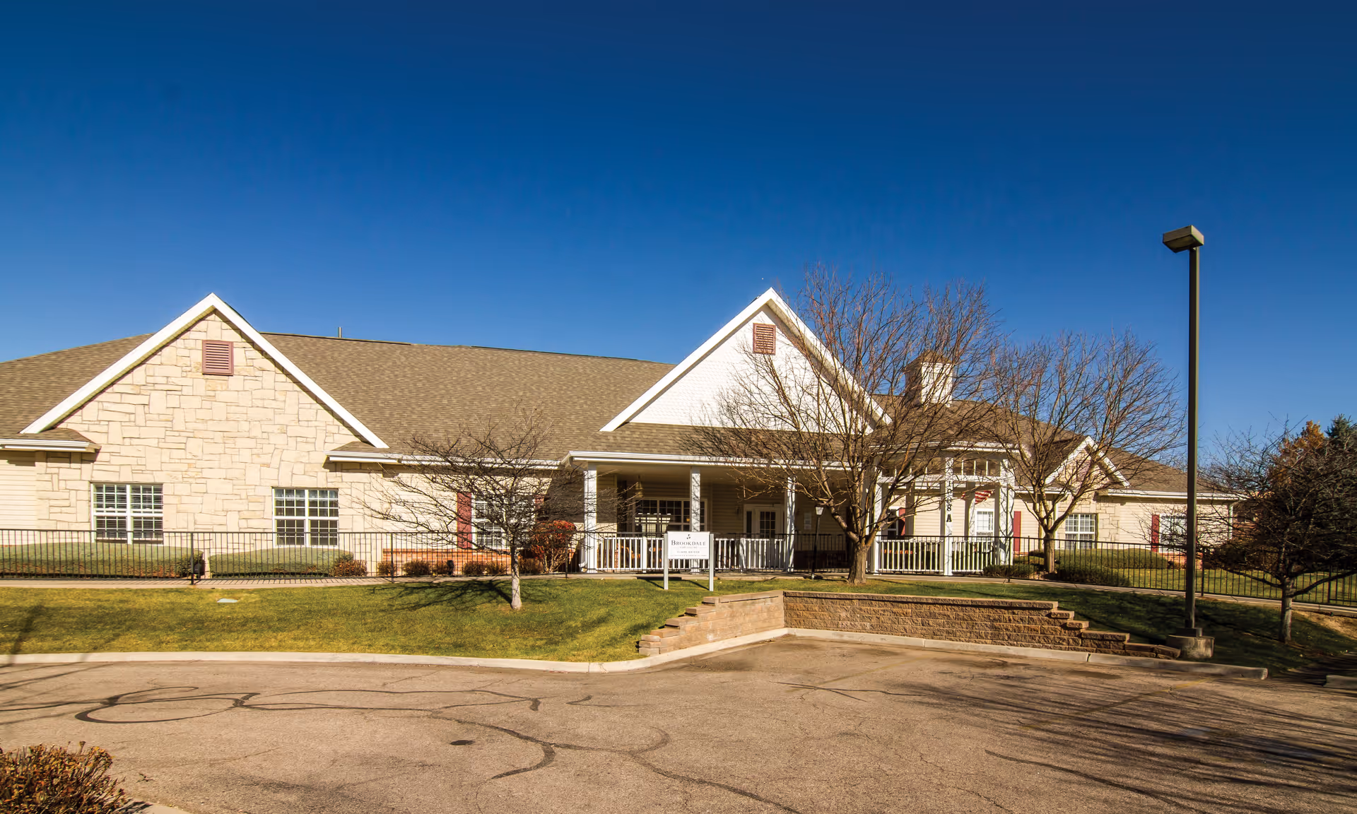 Front view of Brookdale Fort Collins, a single-story senior living facility with stone walls and lawn.