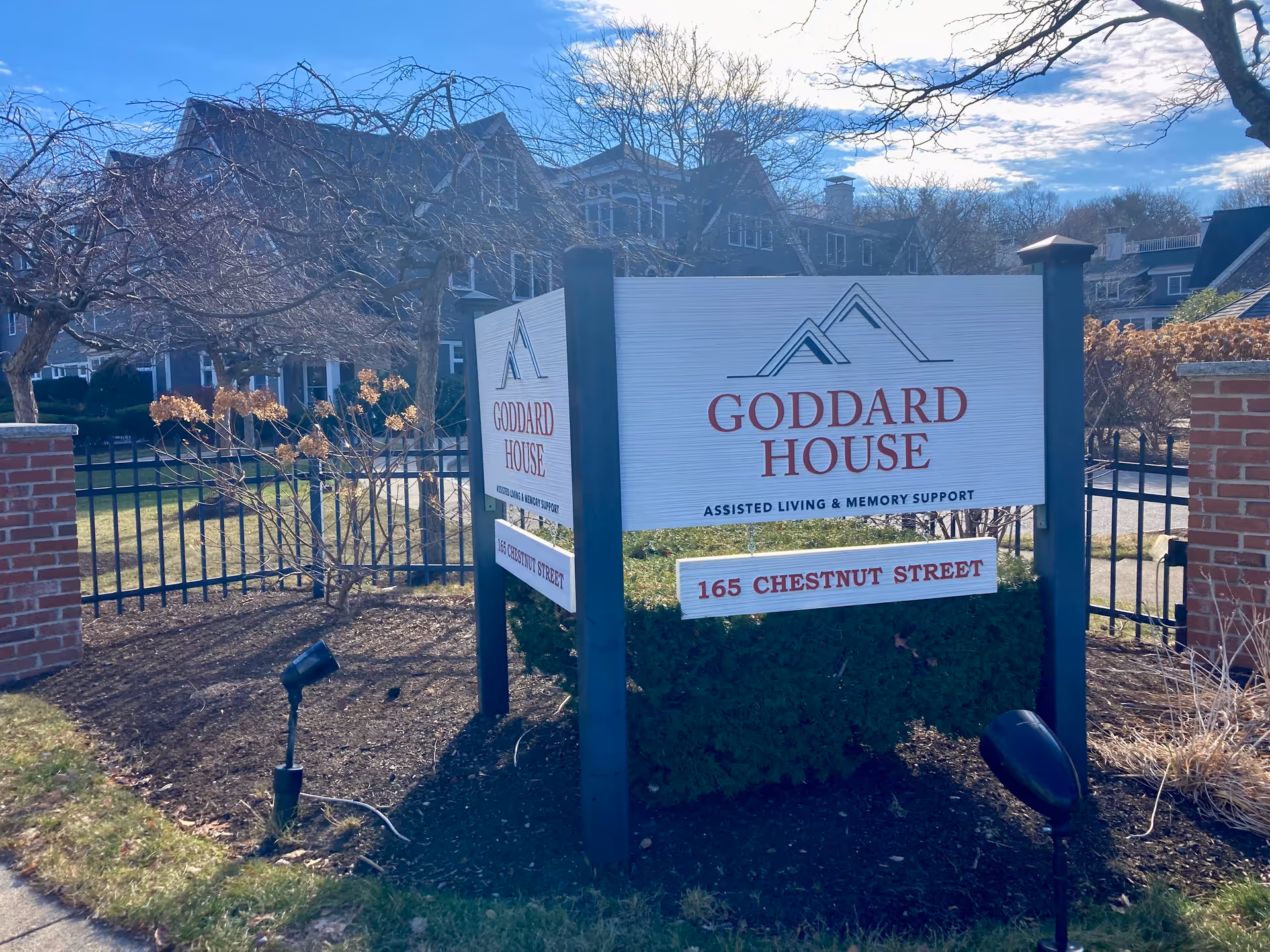 Outdoor sign reading "Goddard House" and "165 Chestnut Street" in front of an assisted living building.