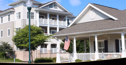 Exterior view of Carroll Lutheran Village showing balconies, porch, and an American flag.