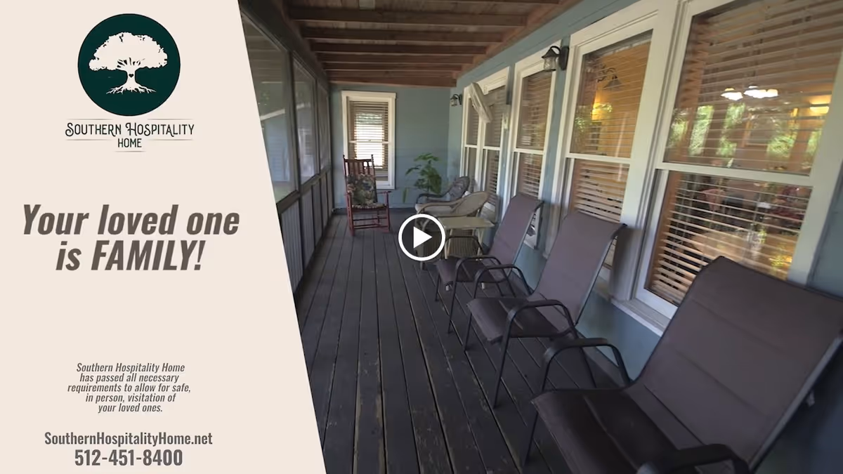 A covered porch area with several chairs lined up along the wall of a building with windows. The porch has a wooden floor and ceiling with exposed beams. There is a rocking chair and a small table with a plant in the background. Text on the left side reads 'Southern Hospitality Home', 'Your loved one is FAMILY!', and contact information for the facility.