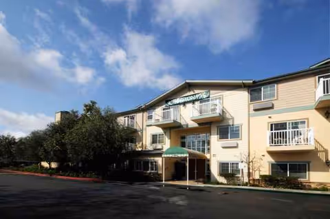 Front exterior of Cypress Place senior living building with entrance canopy and balconies.