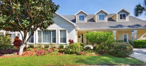 Front exterior of Brookdale Port Orange, a landscaped senior living facility with dormer windows.