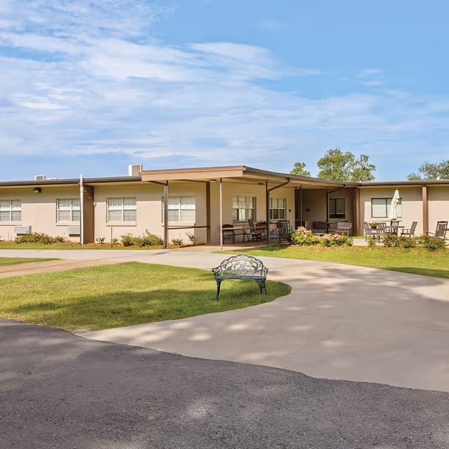 A view of Holly Hill Nursing & Rehabilitation Center featuring a pathway and outdoor seating areas.