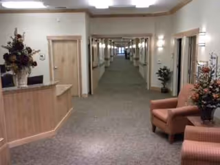 Interior hallway at Stonehenge of Richfield with reception desk, seating, and doors along corridor.