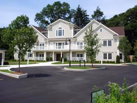 Exterior view of a multi-story senior living building with a circular driveway.
