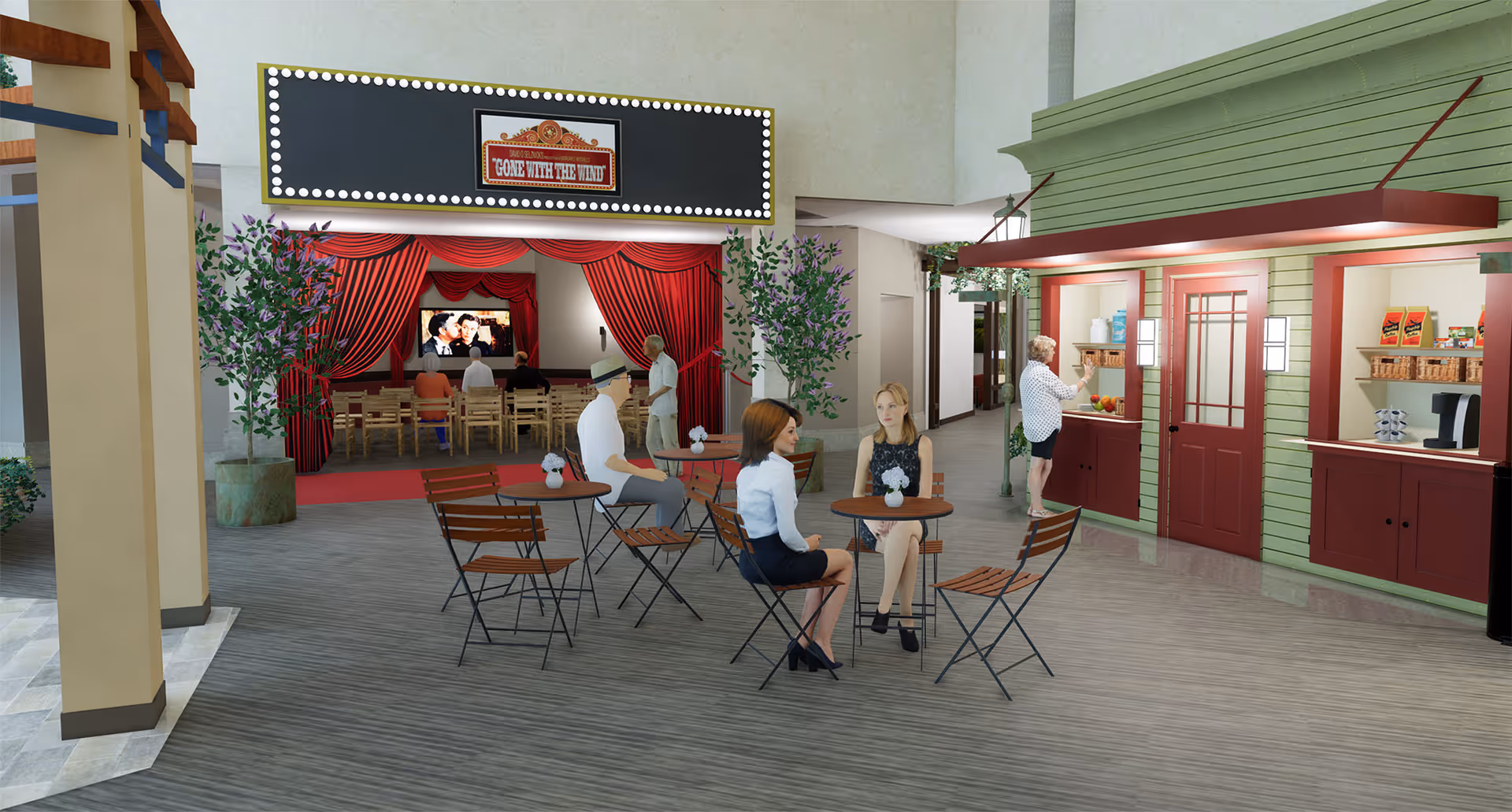 An indoor common area in a senior living facility featuring a small movie theater with a screen showing a classic film, 'Gone With The Wind,' red curtains, and wooden chairs. In front of the theater, there are several round tables with wooden chairs where people are seated and conversing. To the right, there is a green and red concession stand with snacks and a coffee machine, where a person is selecting items.