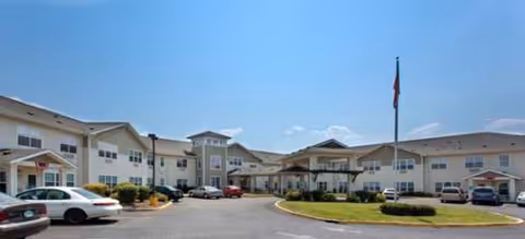 Exterior view of Brookdale College Place with a circular driveway and parked cars.