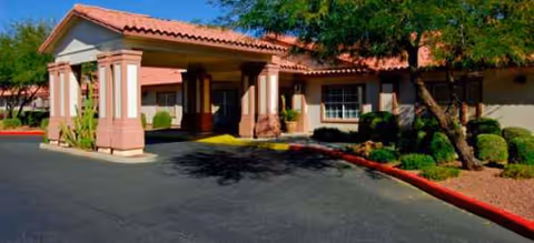 Exterior view of Brookdale Central Chandler entrance with a covered drive and landscaping.