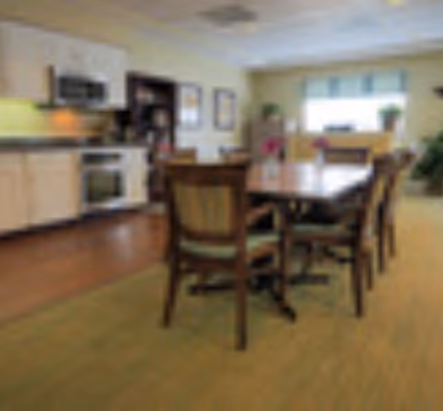 Open dining area with a wooden table and chairs adjacent to a kitchen.