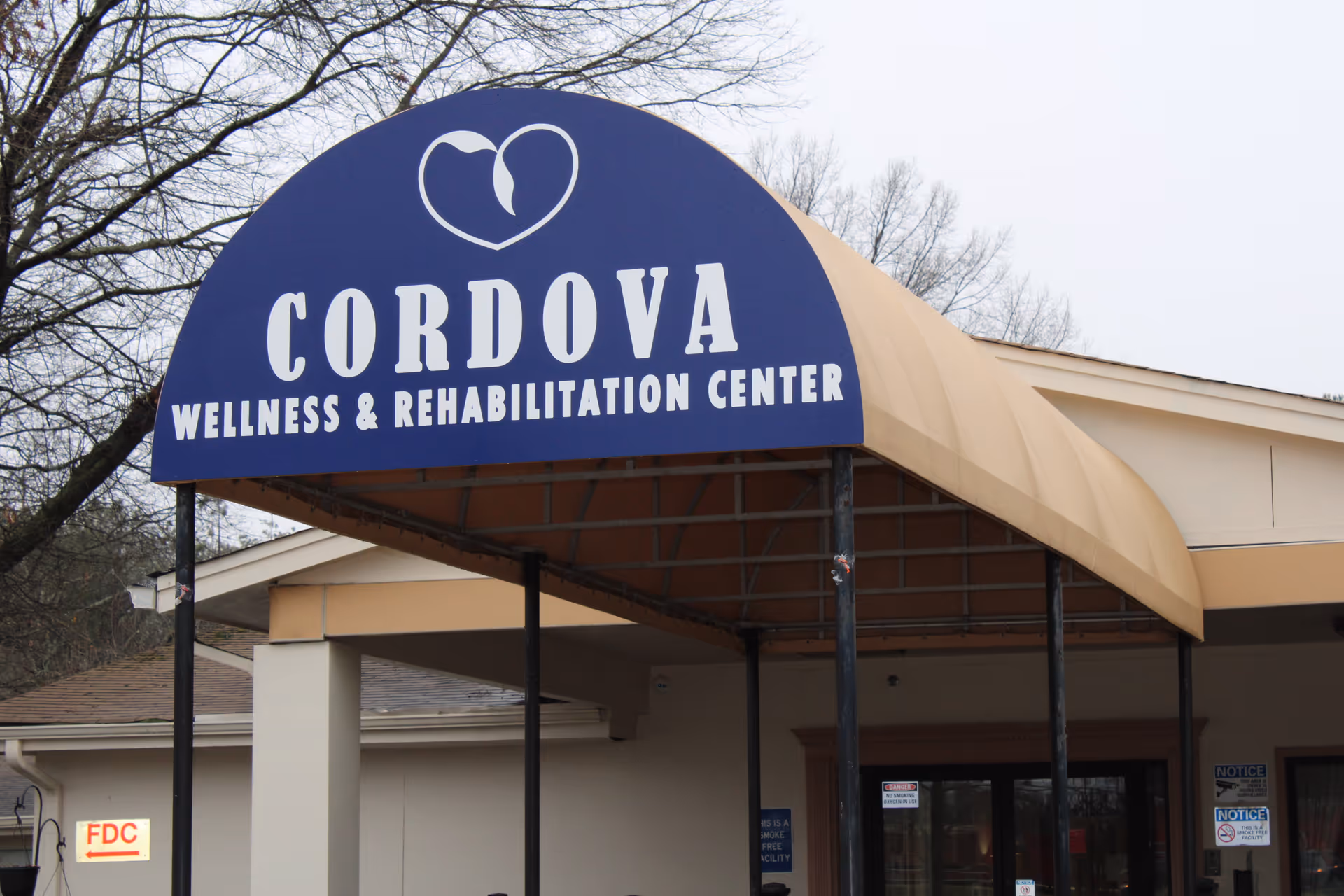 Entrance canopy with a large blue sign reading "CORDOVA Wellness & Rehabilitation Center" over the facility's doorway.