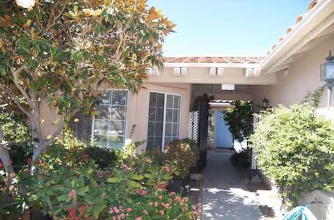 Front view of Paradise Home Care exterior with a walkway and flowering shrubs.