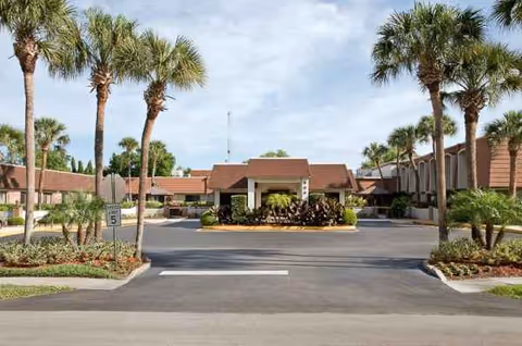 Exterior view of Life Care Center of Altamonte Springs entrance with palm trees and driveway.