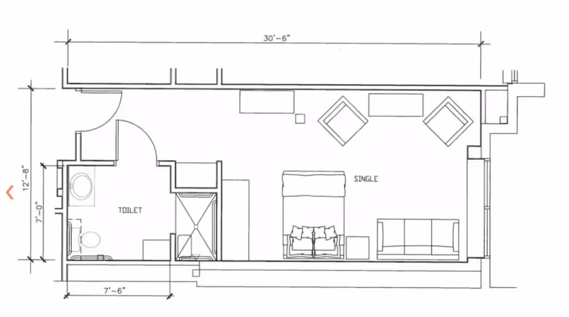 Architectural floor plan of a single room unit at The Carlyle House, showing a bedroom area with a single bed, sofa, two chairs, and a small table, along with an attached bathroom labeled 'Toilet' containing a toilet, sink, and shower.