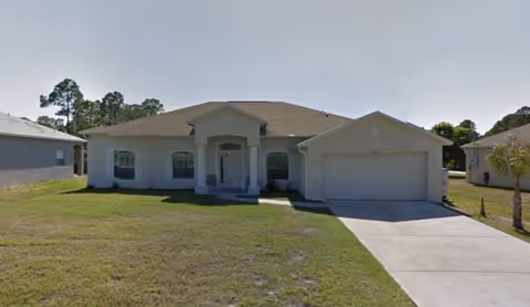 A single-story, house-style facility with a two-car garage and a front lawn.