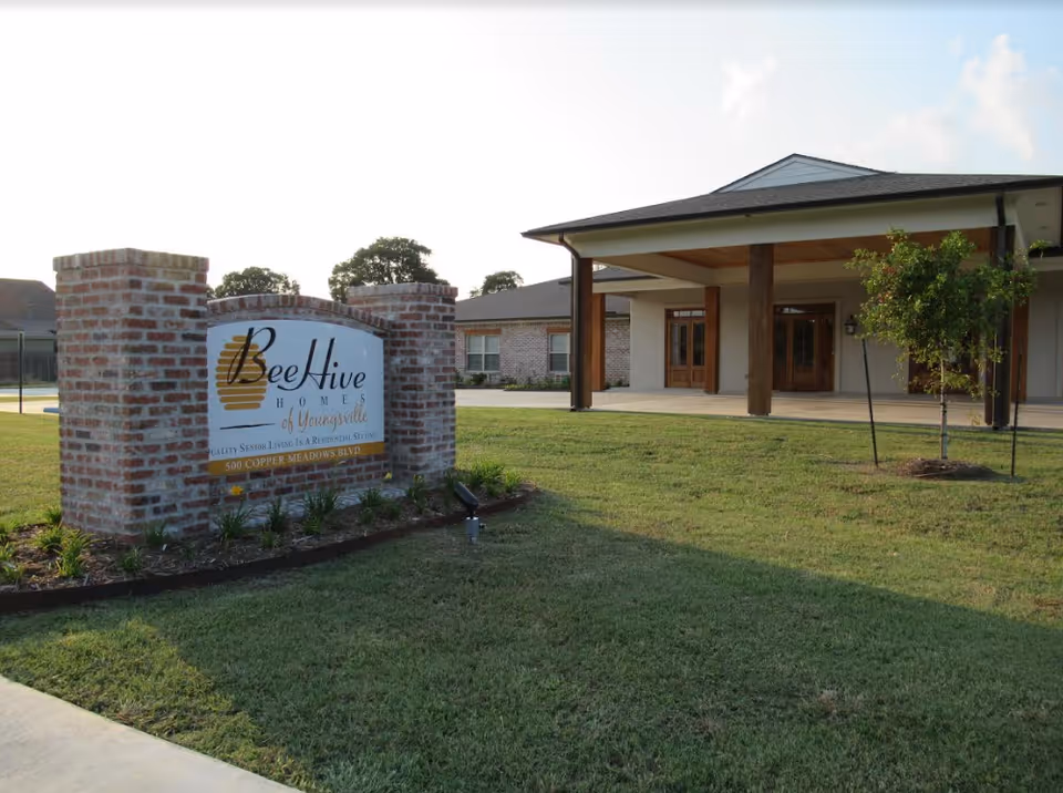 Entrance to BeeHive Homes of Youngsville with brick sign and covered walkway.
